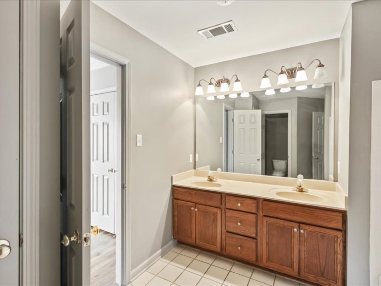 1672 Village Ridge Road, Unit 69 Collierville, TN 38017 - Photo 16 of 23 Bathroom with double vanity, toilet, visible vents, and a sink