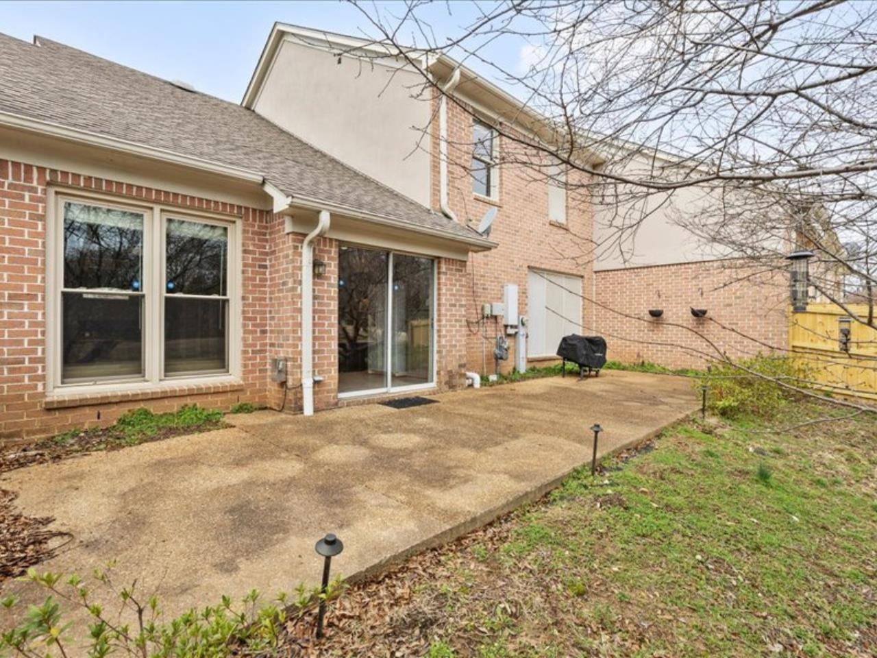 1672 Village Ridge Road, Unit 69 Collierville, TN 38017 - Photo 19 of 23 Rear view of house featuring fence, brick siding, a patio area, and a shingled roof