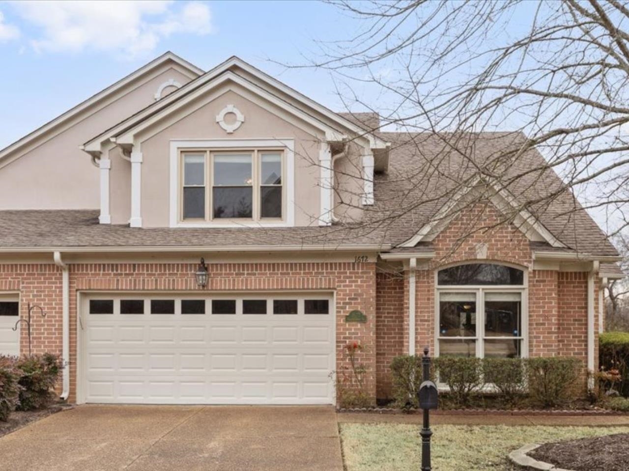 1672 Village Ridge Road, Unit 69 Collierville, TN 38017 - Photo 2 of 23 View of front of house with brick siding, driveway, roof with shingles, and stucco siding