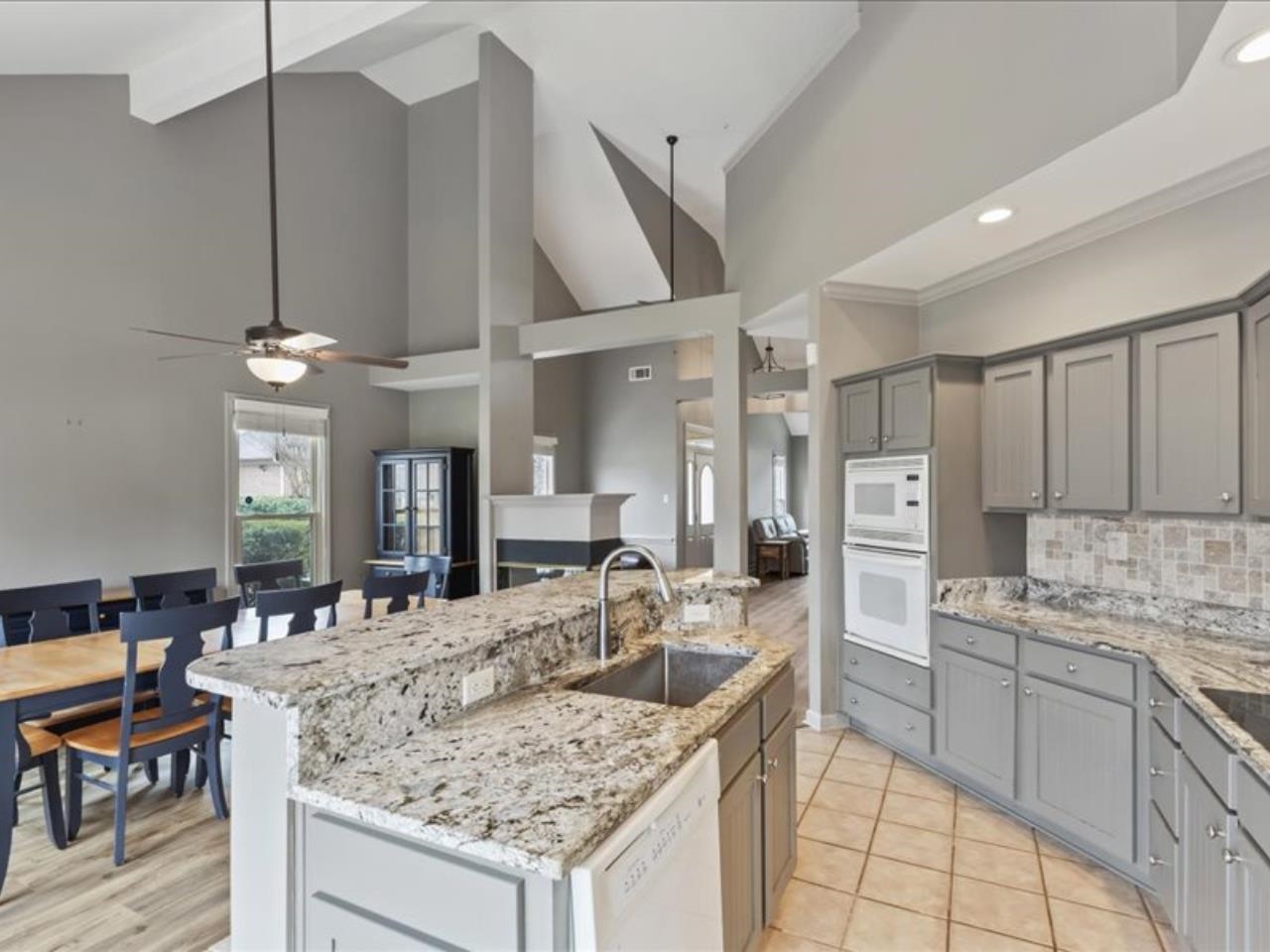 1672 Village Ridge Road, Unit 69 Collierville, TN 38017 - Photo 6 of 23 Kitchen with a sink, decorative backsplash, white appliances, a kitchen island, and gray cabinetry