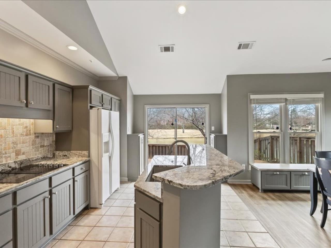 1672 Village Ridge Road, Unit 69 Collierville, TN 38017 - Photo 8 of 23 Kitchen featuring a sink, visible vents, white refrigerator with ice dispenser, light stone counters, and tasteful backsplash