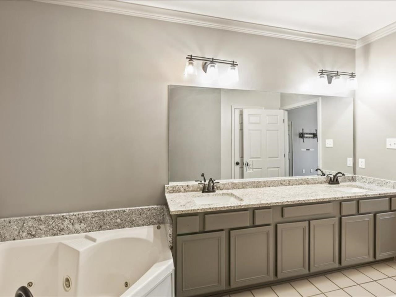 1672 Village Ridge Road, Unit 69 Collierville, TN 38017 - Photo 10 of 23 Bathroom featuring double vanity, crown molding, a tub with jets, and a sink
