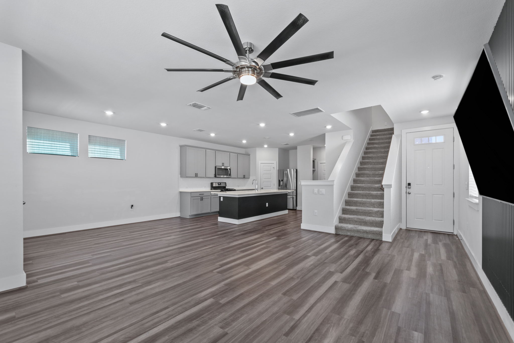 7312 Travertine Spring Drive Austin, TX 78744 - Photo 5 of 32 An open-concept living space with sleek flooring and a contemporary kitchen offers seamless flow and modern design.