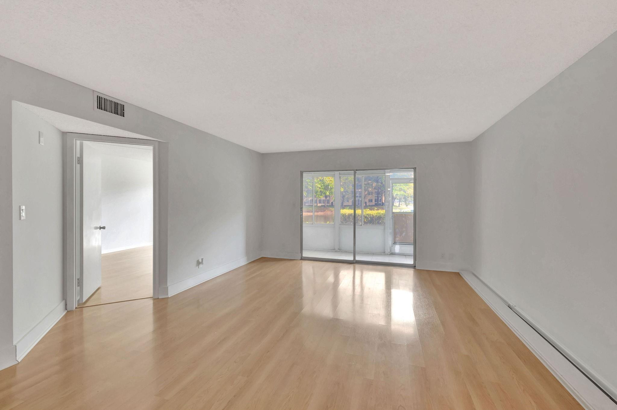 1801 Eleuthera Point, Unit E1 Coconut Creek, FL 33066 - Photo 17 of 50 wooden floor in an empty room with a window