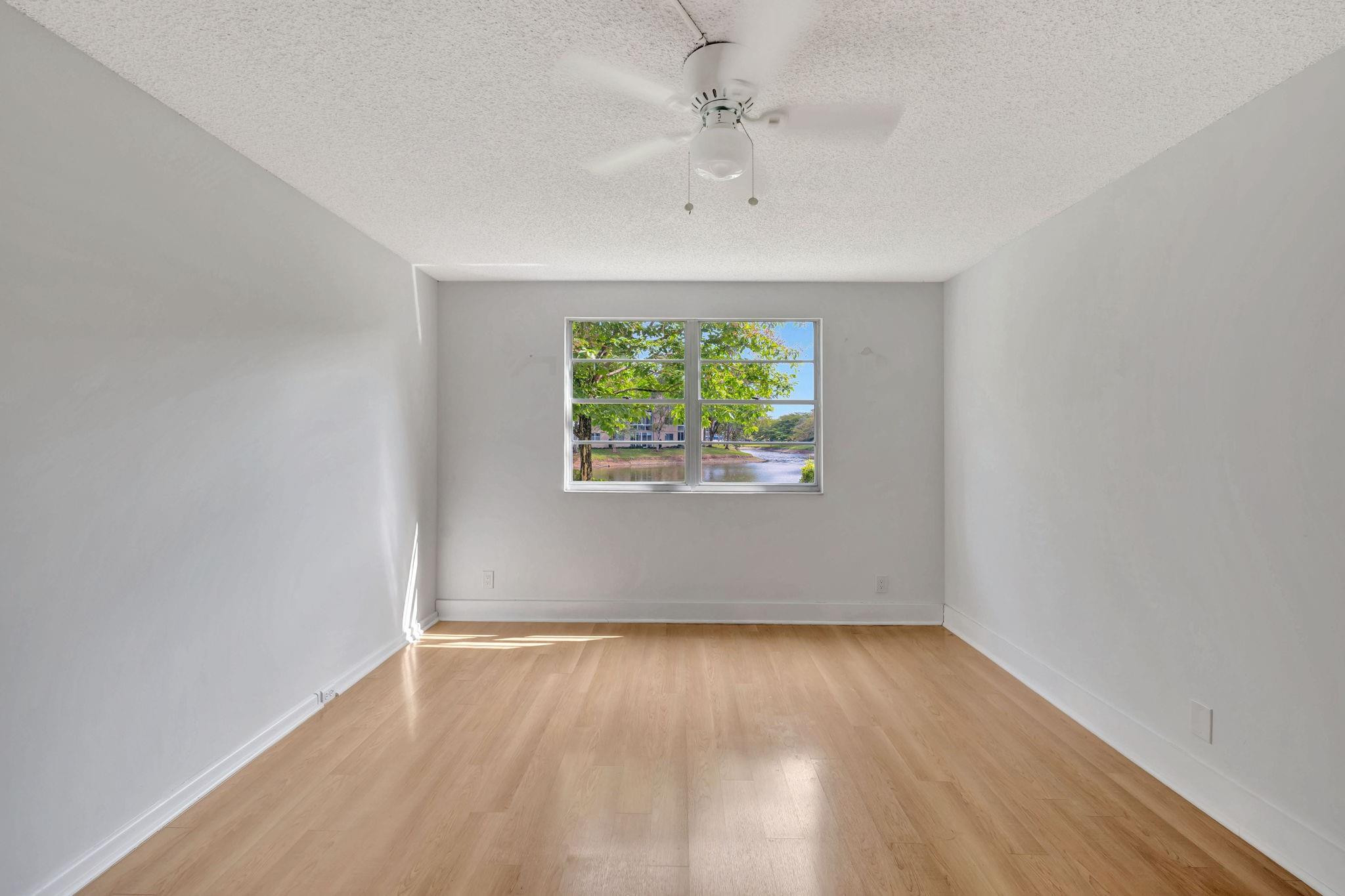 1801 Eleuthera Point, Unit E1 Coconut Creek, FL 33066 - Photo 19 of 50 wooden floor in an empty room with a window