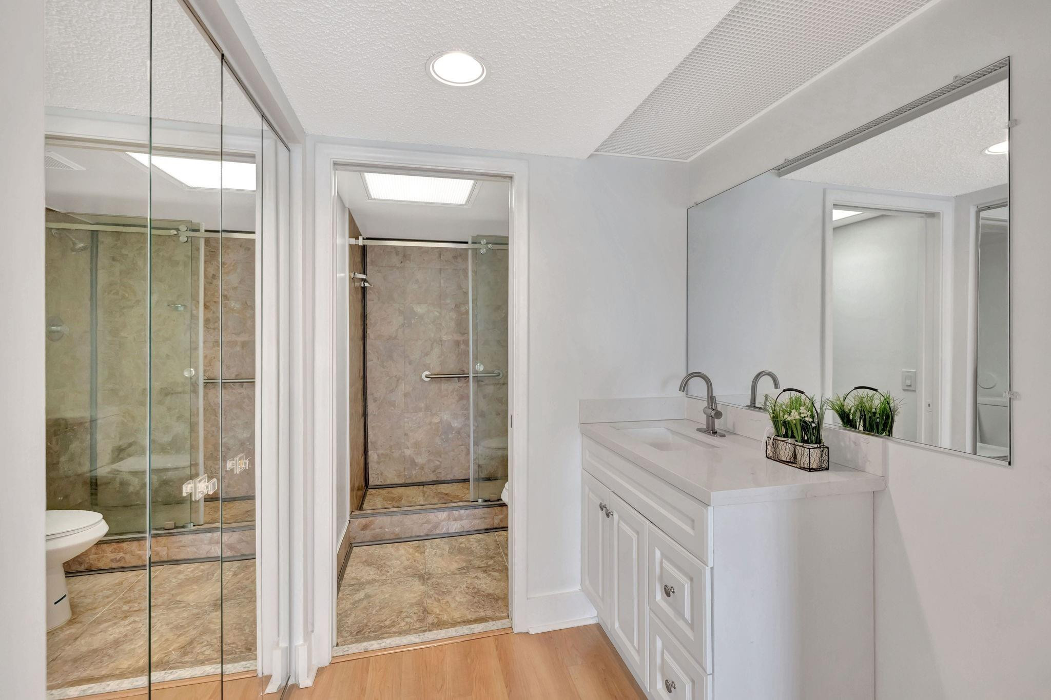 1801 Eleuthera Point, Unit E1 Coconut Creek, FL 33066 - Photo 21 of 50 a bathroom with a granite countertop sink and a mirror