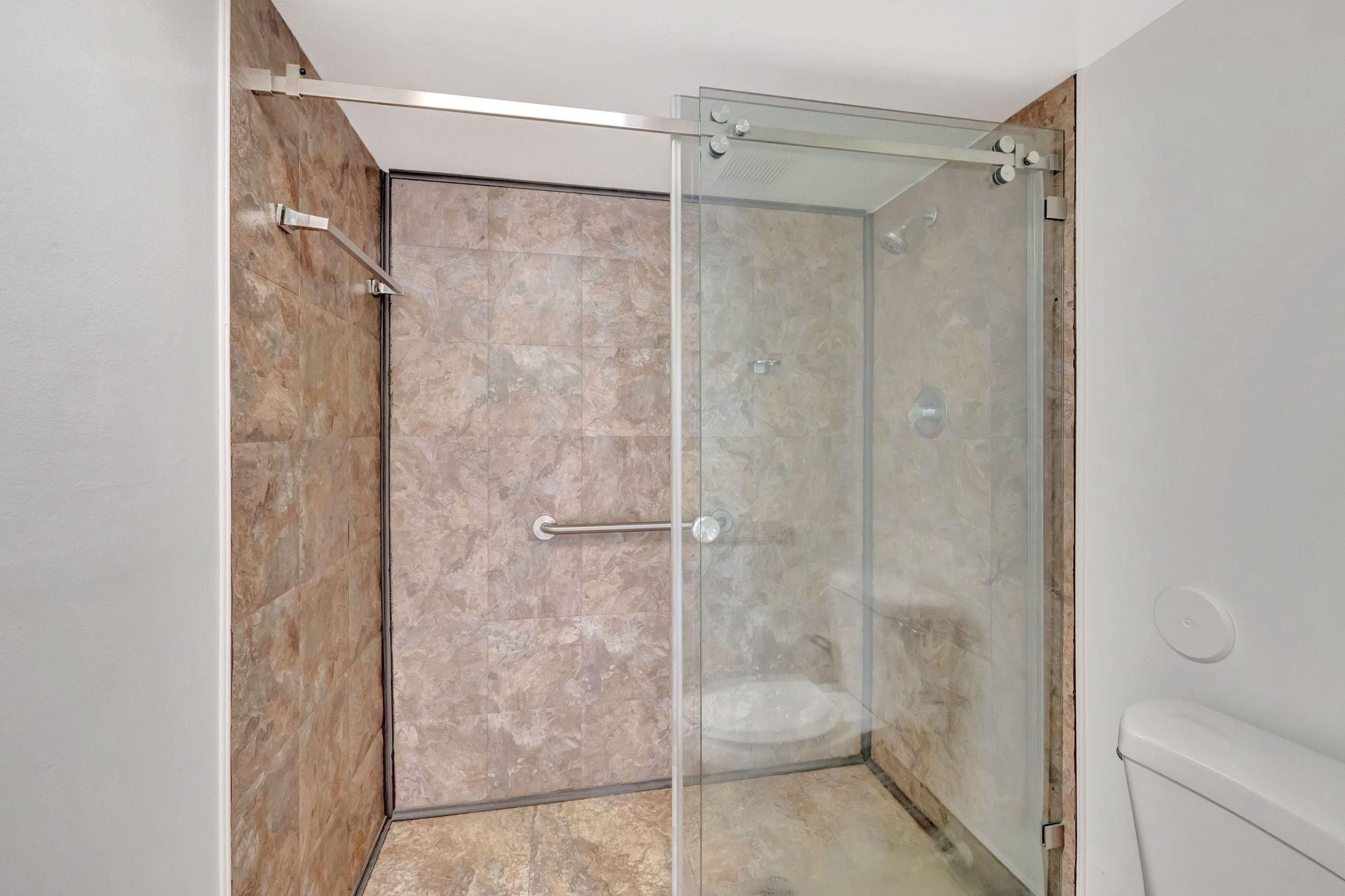 1801 Eleuthera Point, Unit E1 Coconut Creek, FL 33066 - Photo 22 of 50 a bathroom with a glass shower door