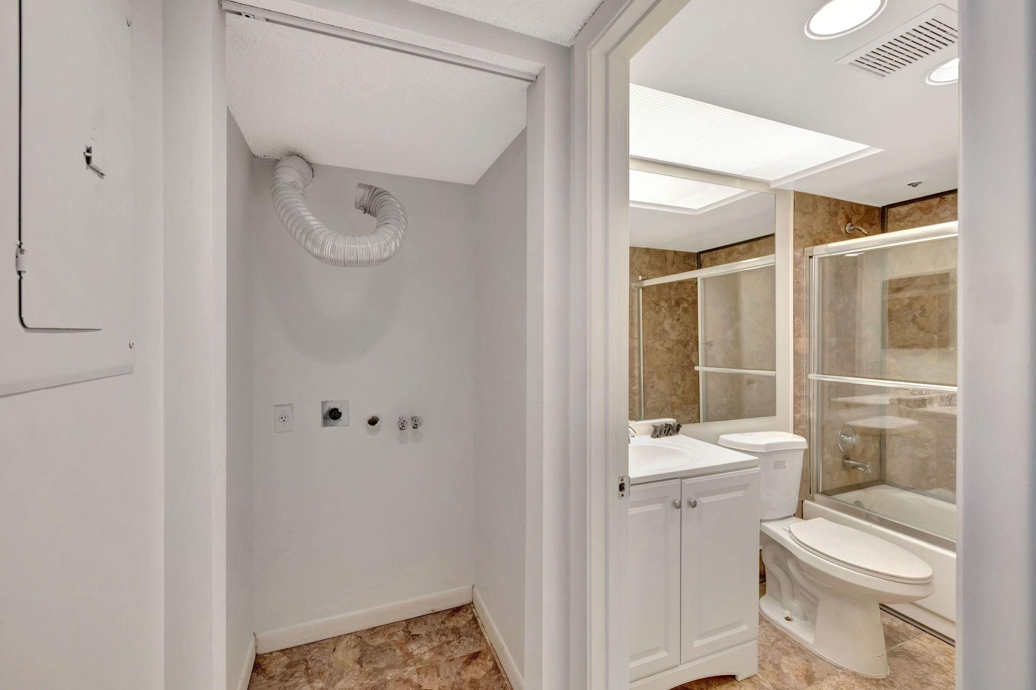 1801 Eleuthera Point, Unit E1 Coconut Creek, FL 33066 - Photo 29 of 50 a bathroom with a toilet sink and a mirror