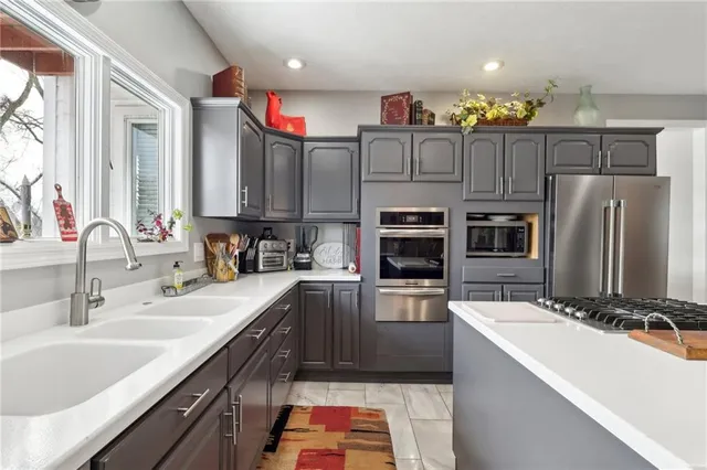 a kitchen with stainless steel appliances a sink stove and refrigerator