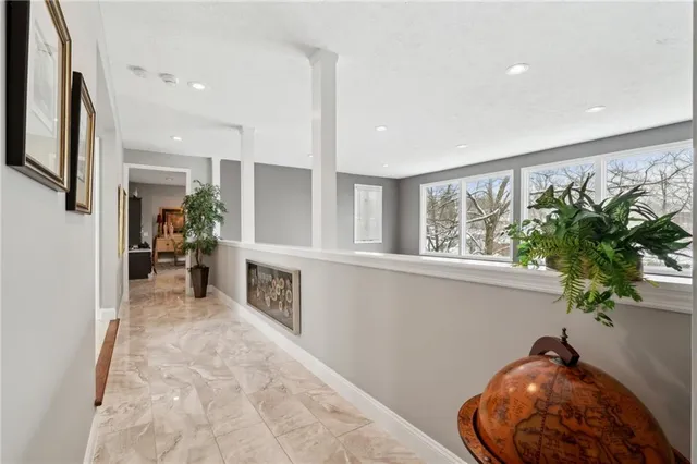 a view of a hallway with furniture and a potted plant