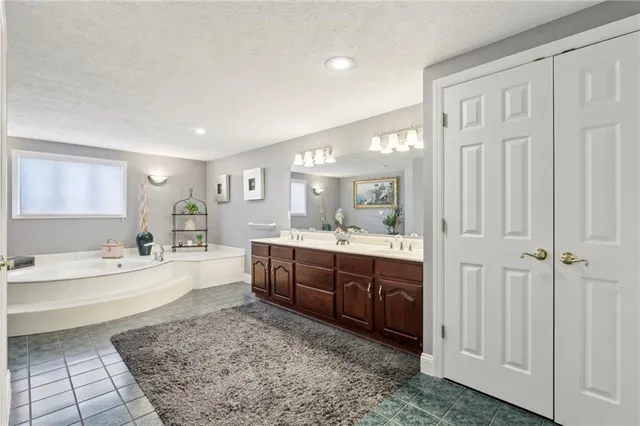 a large bathroom with a tub a double vanity sink a mirror and a shower