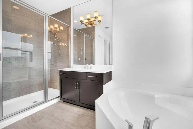 a bathroom with a bathtub shower sink and mirror