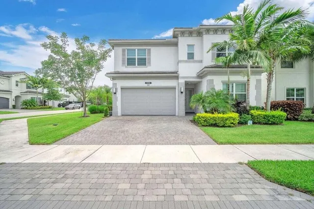 a front view of a house with a yard and a garage