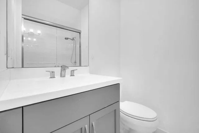 a bathroom with a sink a toilet a mirror and vanity