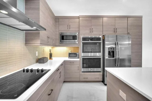a kitchen with stainless steel appliances a stove a sink and a refrigerator