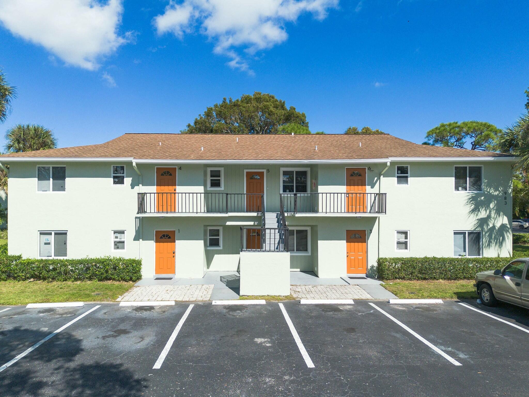 983 Northwest Spruce Ridge Drive, Unit 2 Stuart, FL 34994 - Photo 31 of 55 a front view of a house with a yard and garage