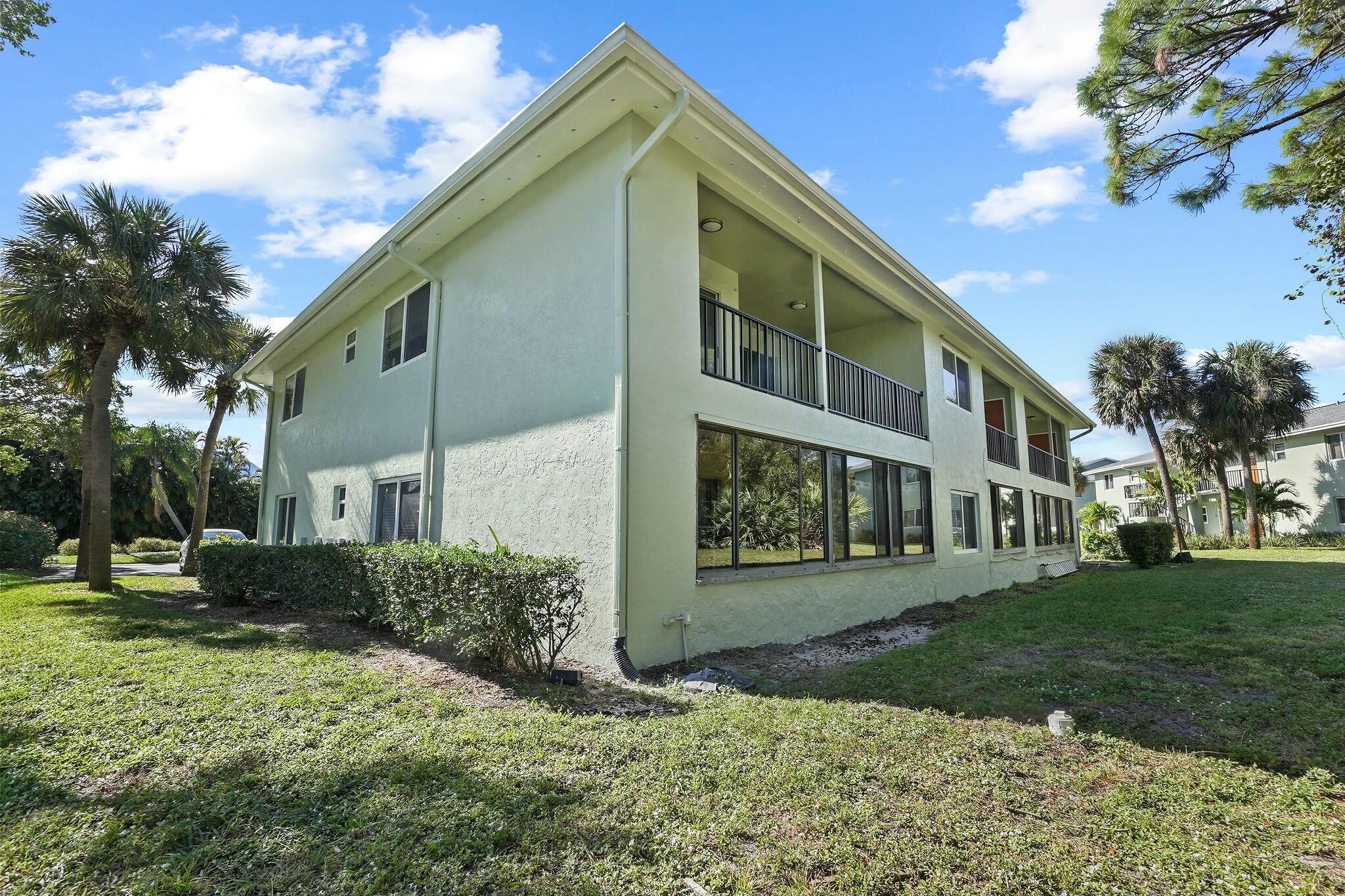 983 Northwest Spruce Ridge Drive, Unit 2 Stuart, FL 34994 - Photo 46 of 55 a front view of a house with a yard