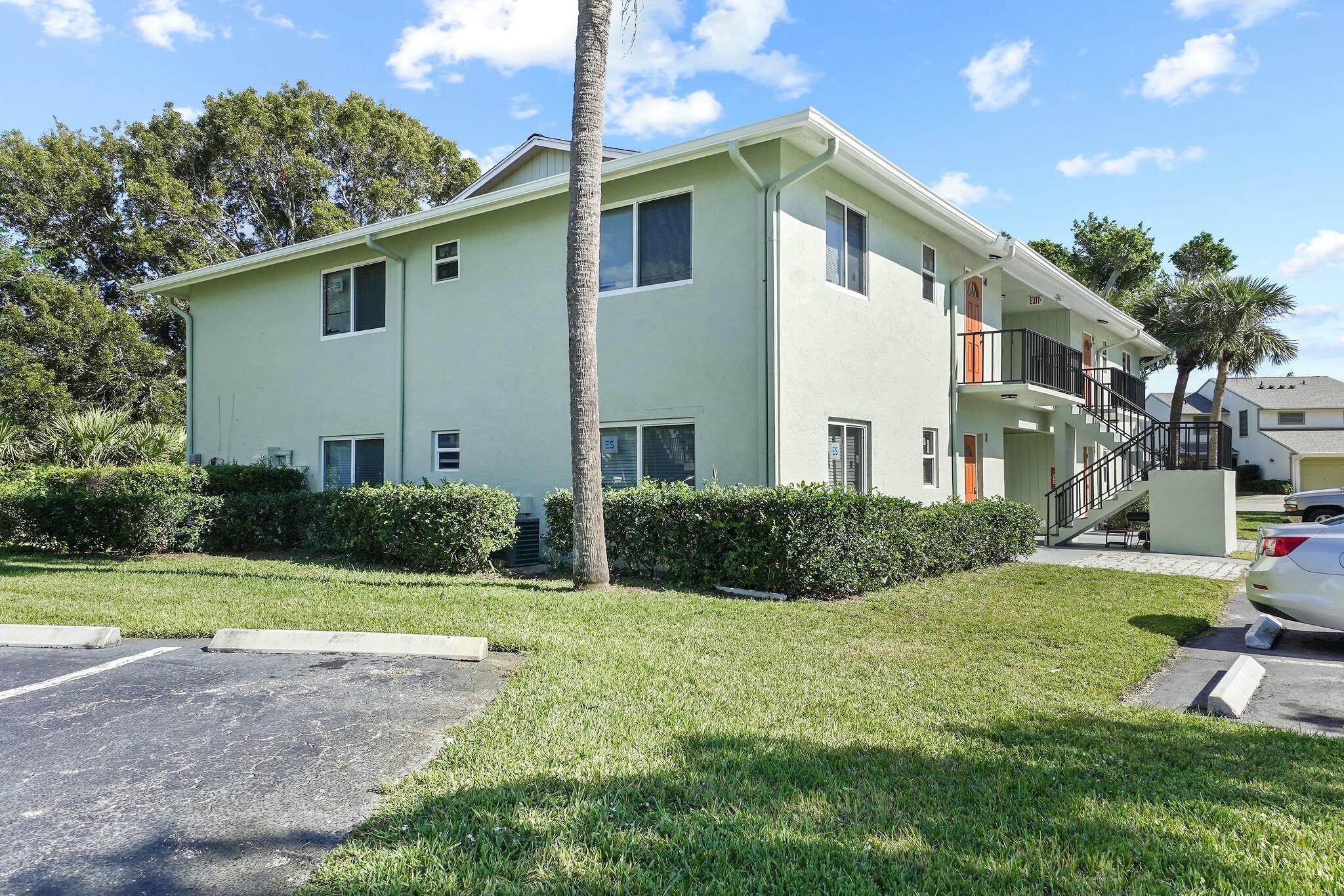 983 Northwest Spruce Ridge Drive, Unit 2 Stuart, FL 34994 - Photo 47 of 55 a front view of a house with a yard