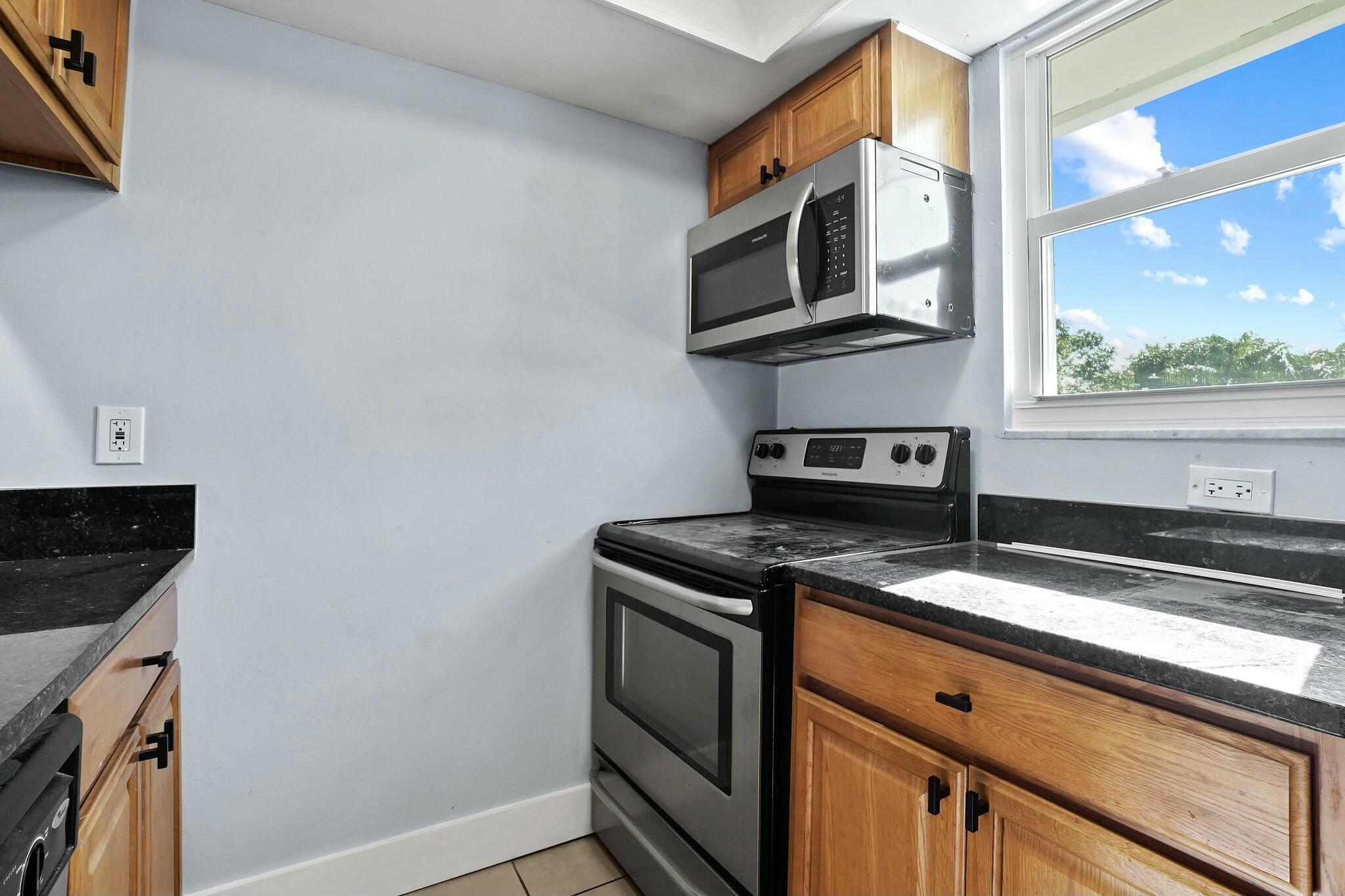 983 Northwest Spruce Ridge Drive, Unit 2 Stuart, FL 34994 - Photo 10 of 55 a kitchen with a stove and a microwave