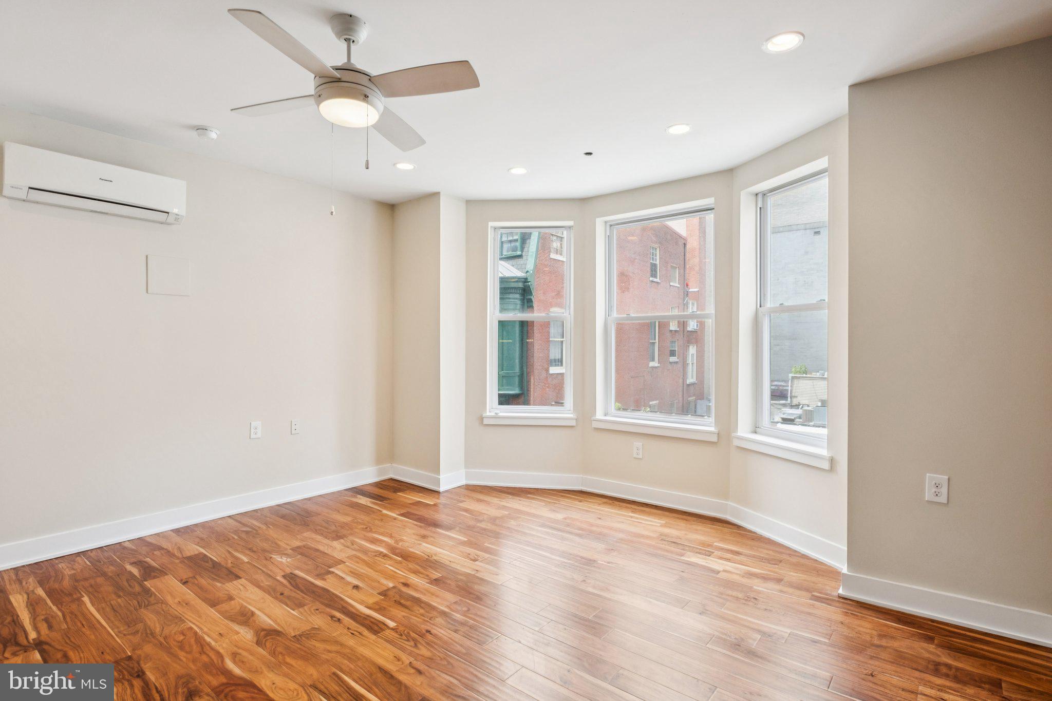 131 South 13th Street, Unit 3F Philadelphia, PA 19107 - Photo 2 of 14 a view of an empty room with a window and wooden floor
