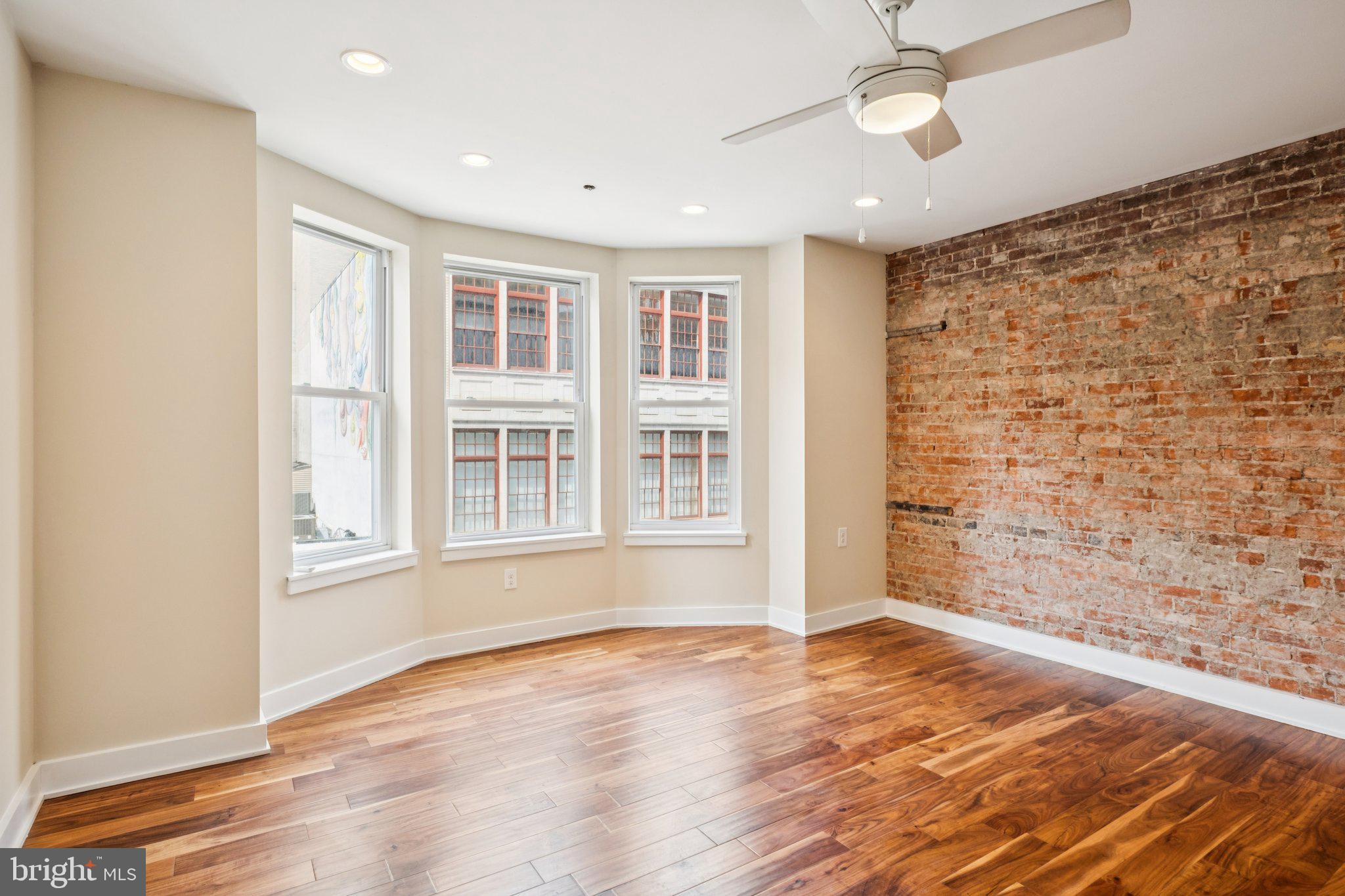 131 South 13th Street, Unit 3F Philadelphia, PA 19107 - Photo 3 of 14 a view of an empty room with a window and wooden floor