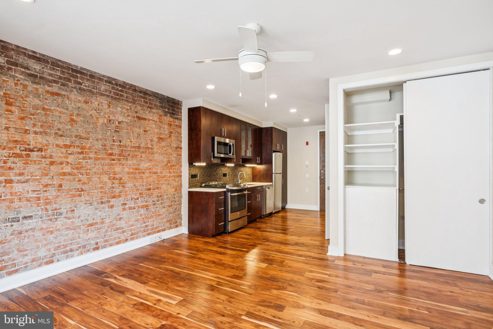 131 South 13th Street, Unit 3F Philadelphia, PA 19107 - Photo 4 of 14 a kitchen with stainless steel appliances a refrigerator and a stove top oven