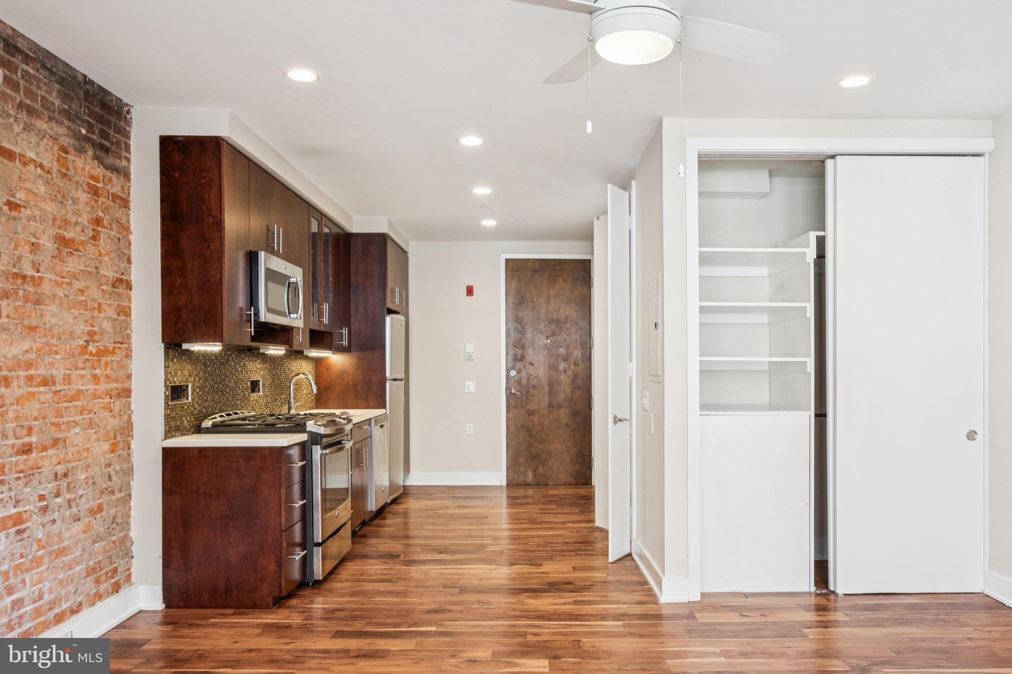 131 South 13th Street, Unit 3F Philadelphia, PA 19107 - Photo 5 of 14 a kitchen with stainless steel appliances granite countertop a refrigerator and a stove top oven