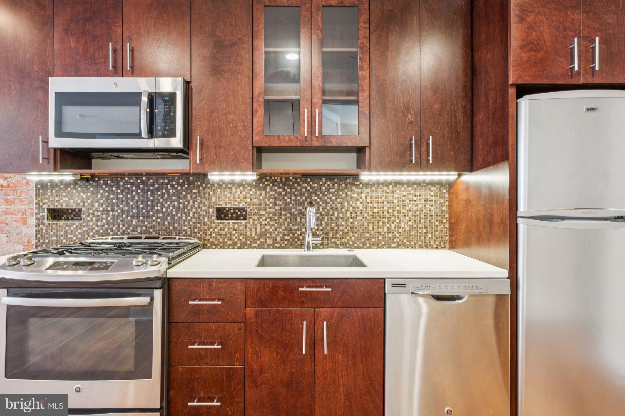 131 South 13th Street, Unit 3F Philadelphia, PA 19107 - Photo 7 of 14 a kitchen with stainless steel appliances granite countertop a sink stove and refrigerator
