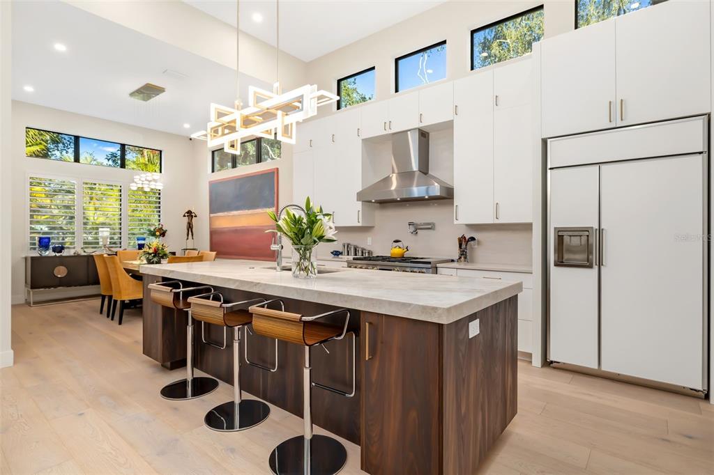1879 Hibiscus Street Sarasota, FL 34239 - Photo 12 of 84 a kitchen with stainless steel appliances a table chairs and a refrigerator