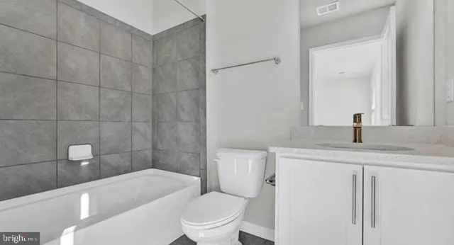 a bathroom with a sink a toilet a mirror and bathtub