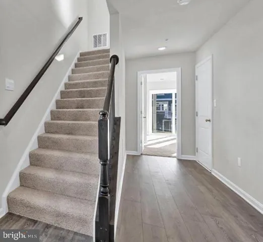 a view of an entryway with wooden floor and door