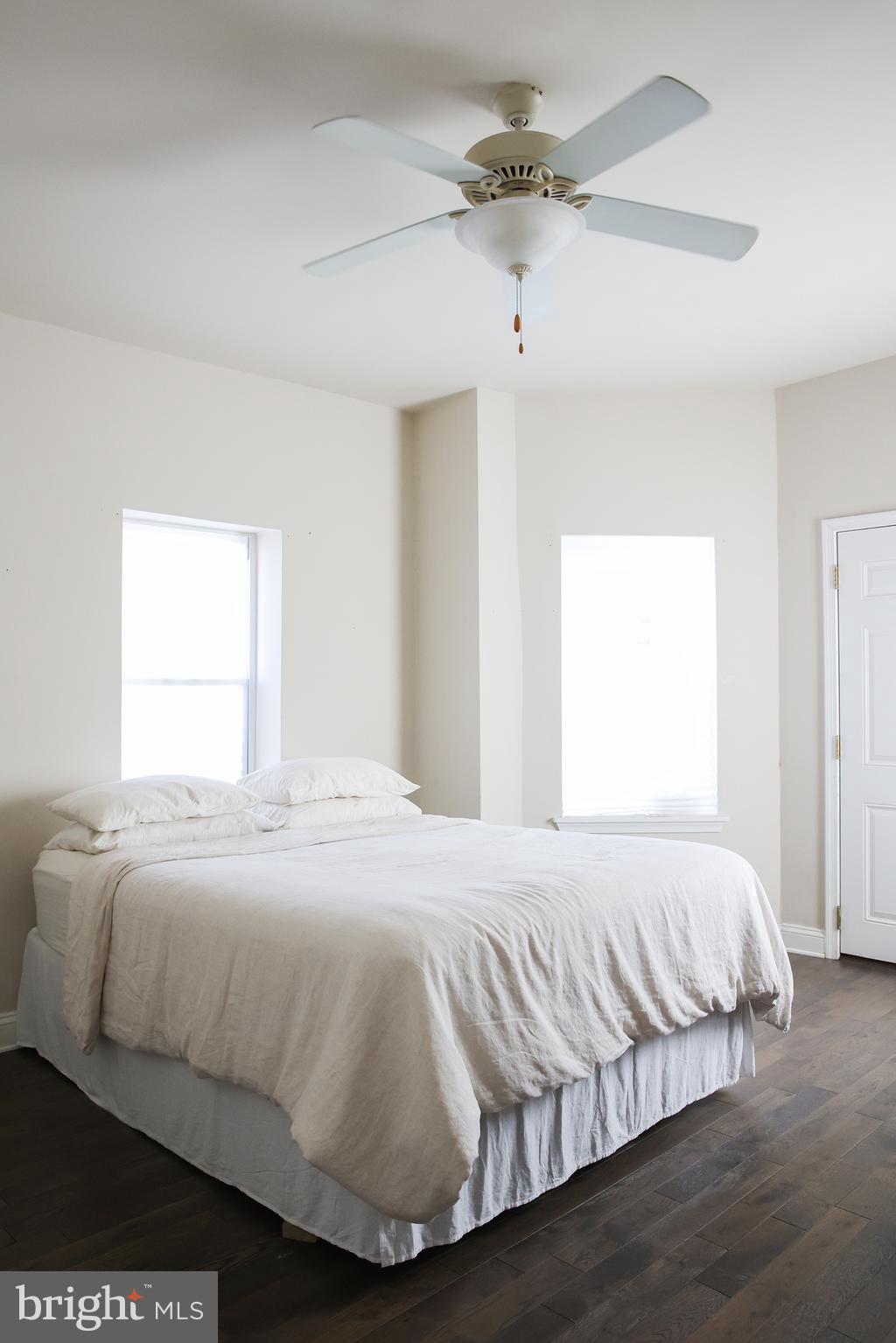 2226 Eutaw Place, Unit 3 Baltimore, MD 21217 - Photo 12 of 15 a bedroom with a bed and wooden floor
