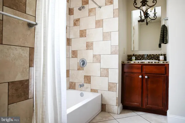 a bathroom with a bathtub sink vanity and mirror