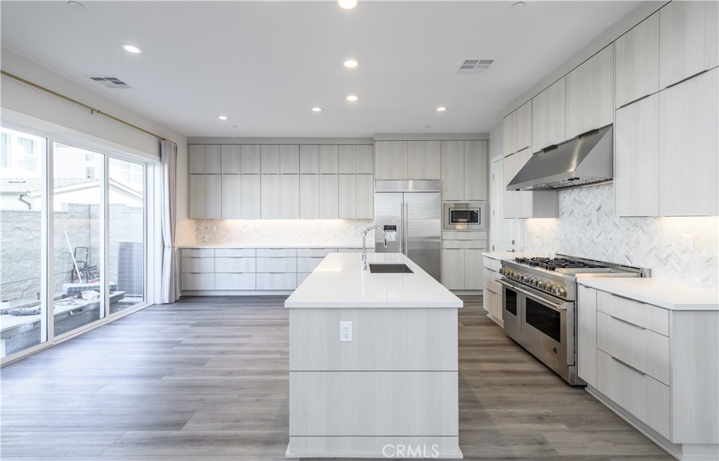 240 Longden Lake Forest, CA 92630 - Photo 6 of 32 a kitchen with a sink stainless steel appliances granite countertop a stove and a sink