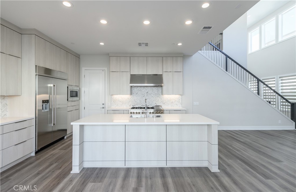 240 Longden Lake Forest, CA 92630 - Photo 8 of 32 a kitchen with a sink stainless steel appliances and cabinets
