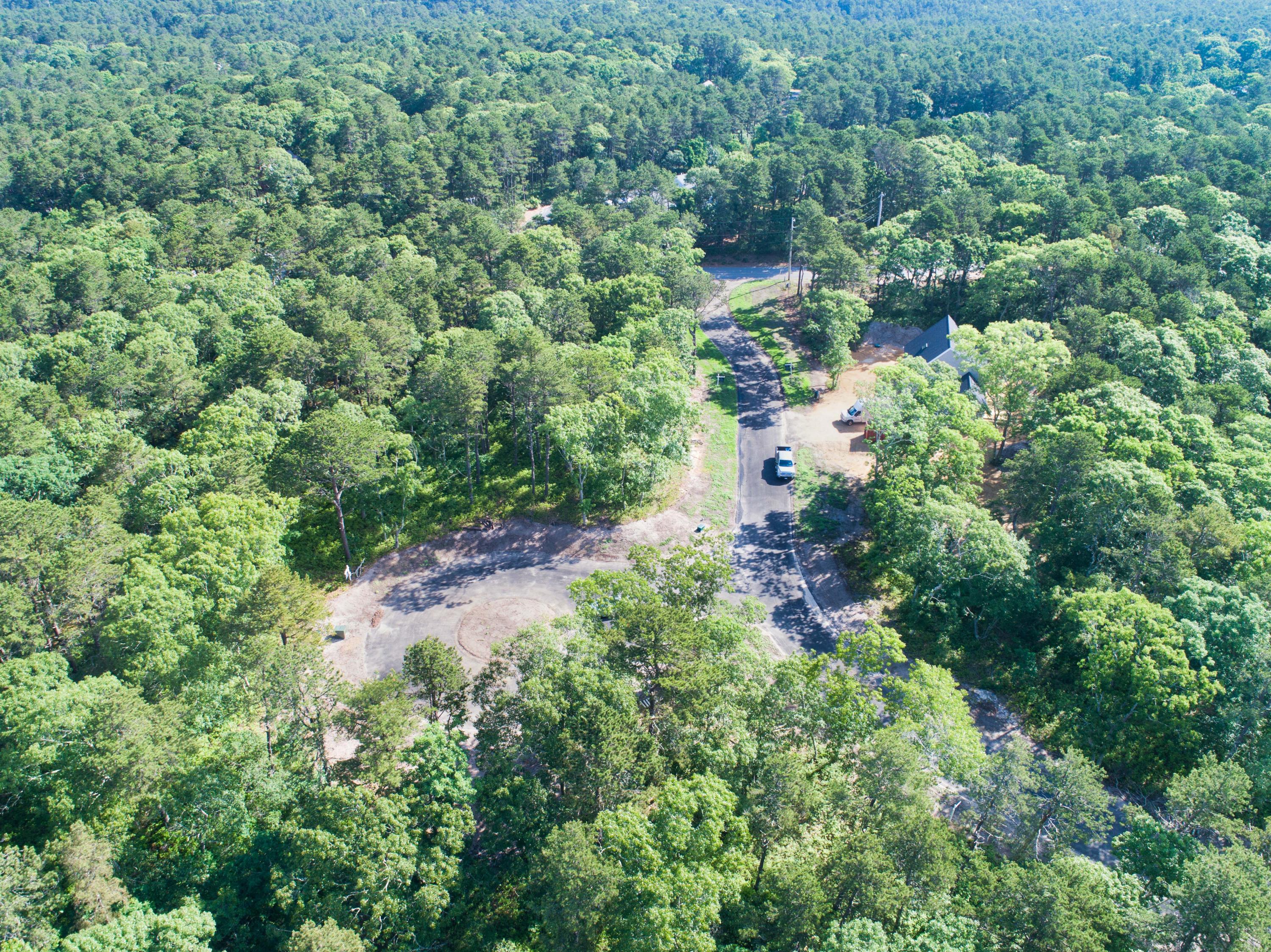 an aerial view of residential house with outdoor space and trees all around