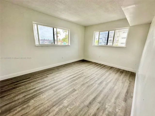 a view of a room with wooden floor and white walls
