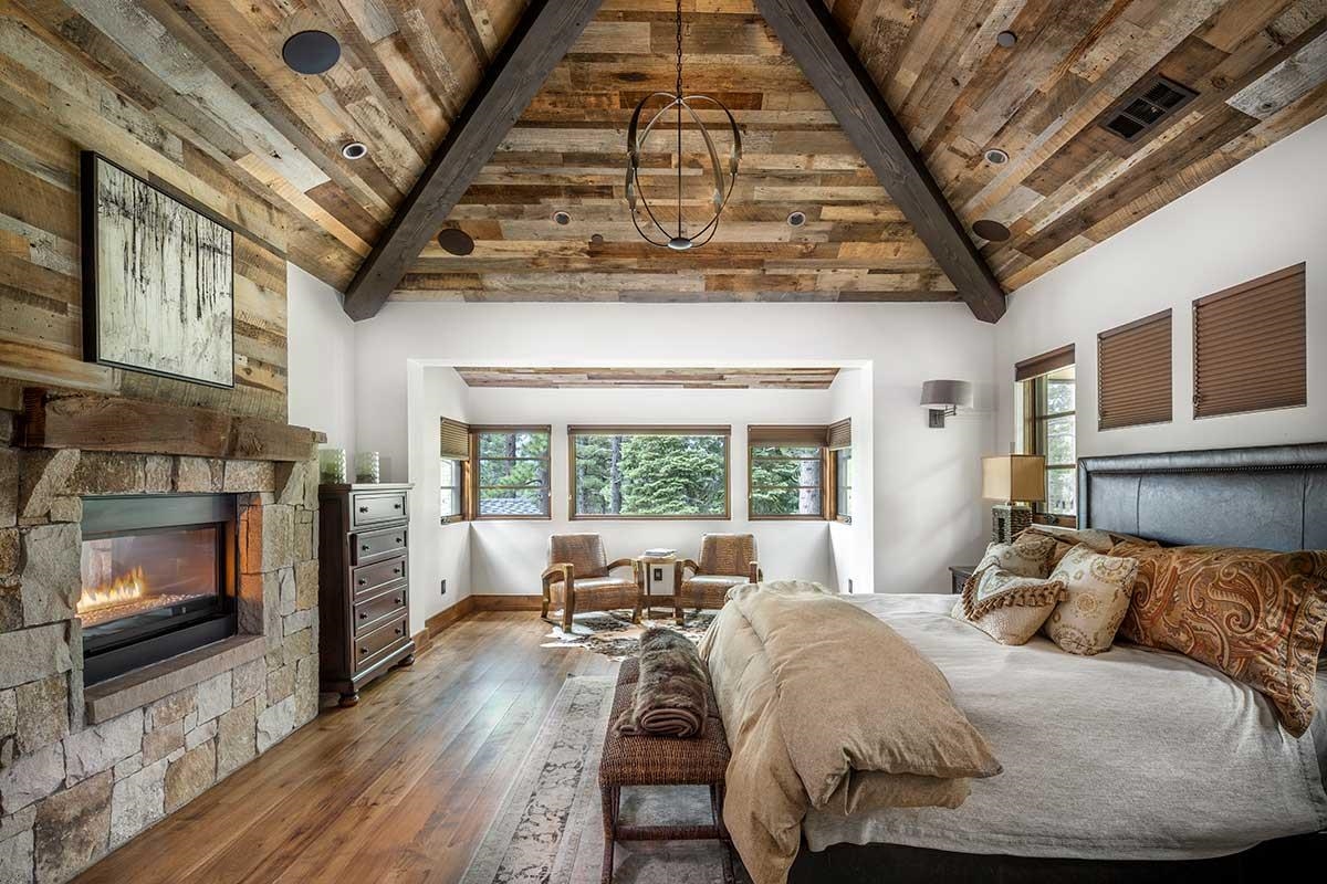 9619 Dunsmuir Way Truckee, CA 96161 - Photo 14 of 24 a bed sitting in a bedroom next to a fireplace with a large window