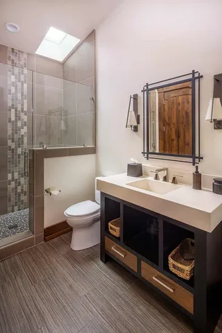 a bathroom with a sink a toilet and shower