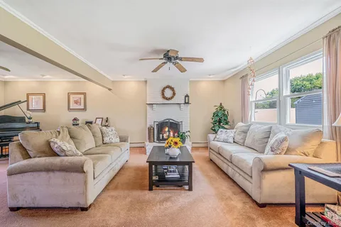 a living room with furniture a fireplace and a large window