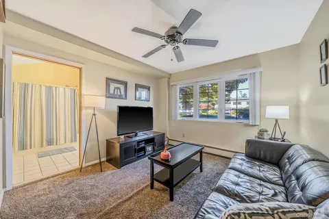 a living room with furniture a window and a flat screen tv