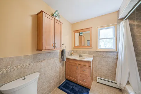 a bathroom with a sink a toilet and a window