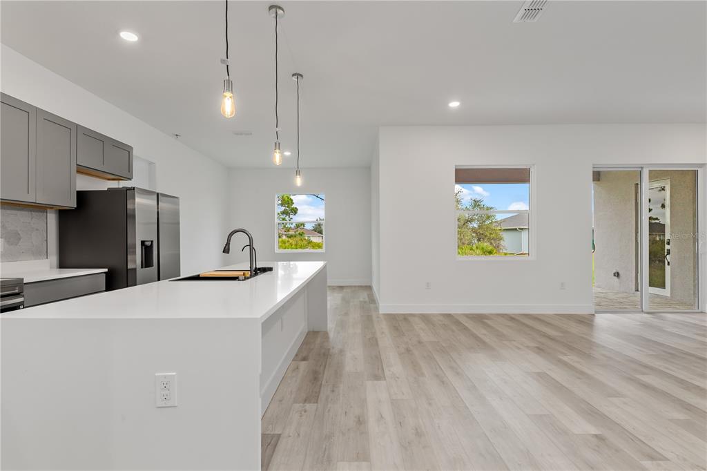 13514 Keystone Boulevard Port Charlotte, FL 33981 - Photo 3 of 42 a view of a kitchen with a sink wooden cabinets and entryway
