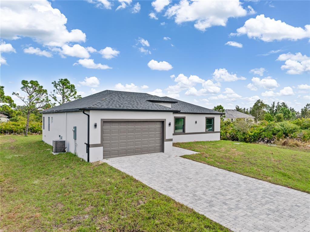 13514 Keystone Boulevard Port Charlotte, FL 33981 - Photo 35 of 42 a front view of a house with a yard and garage