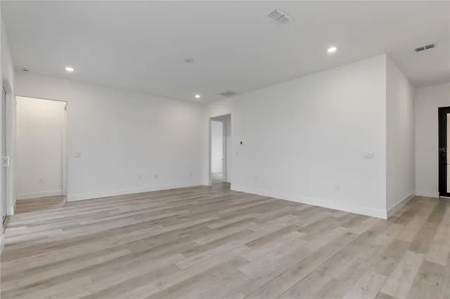 a view of an empty room with wooden floor