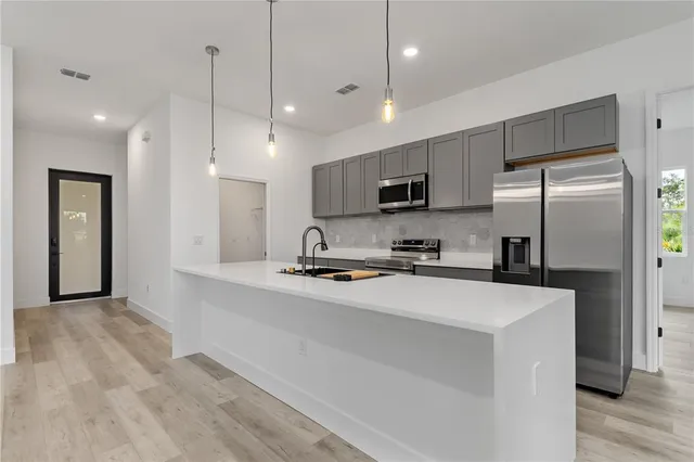 a kitchen with stainless steel appliances a refrigerator sink and microwave