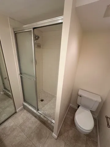 a bathroom with a granite countertop toilet and a shower