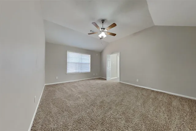 an empty room with windows and ceiling fan