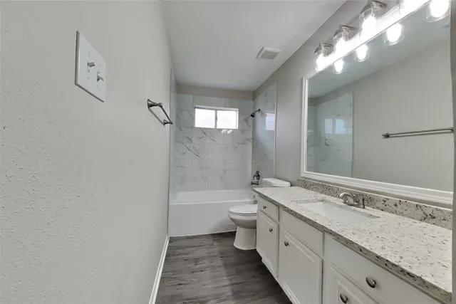 a bathroom with a double vanity sink toilet and shower