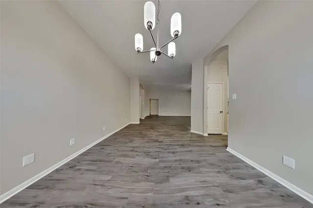 a view of a chandelier fan and hardwood floor